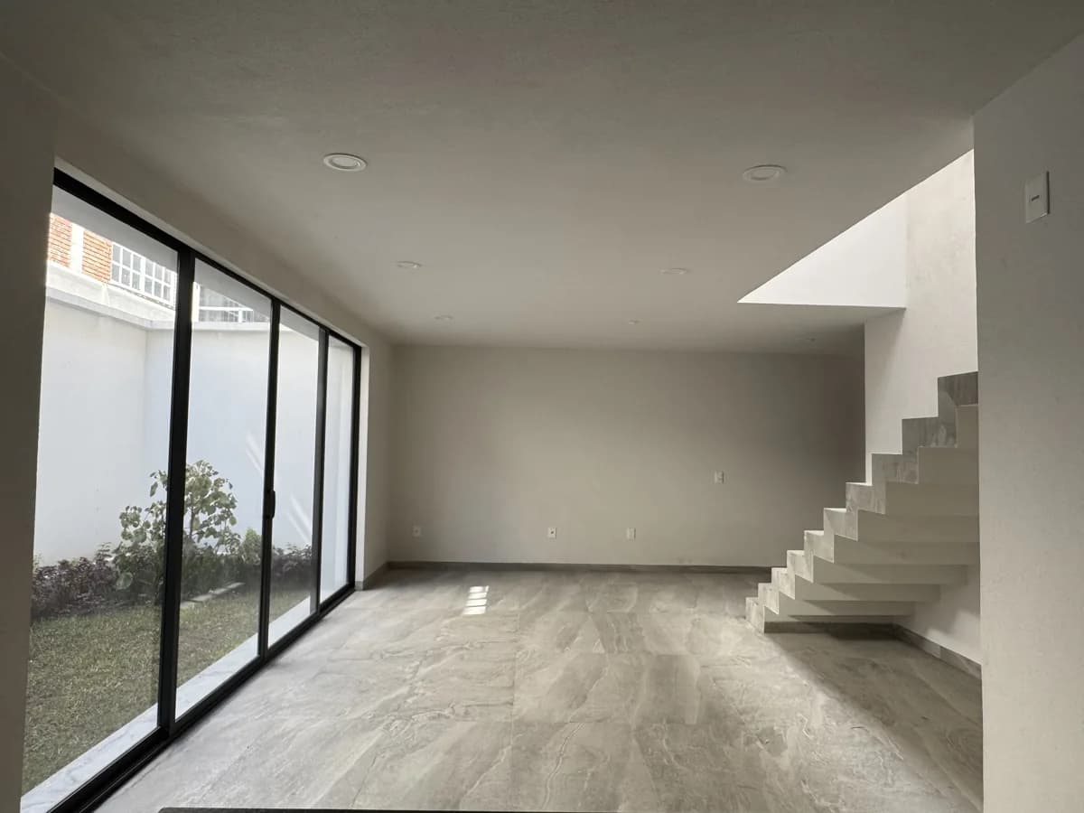 Sala del modelo Aqua con ventanal al jardín privado