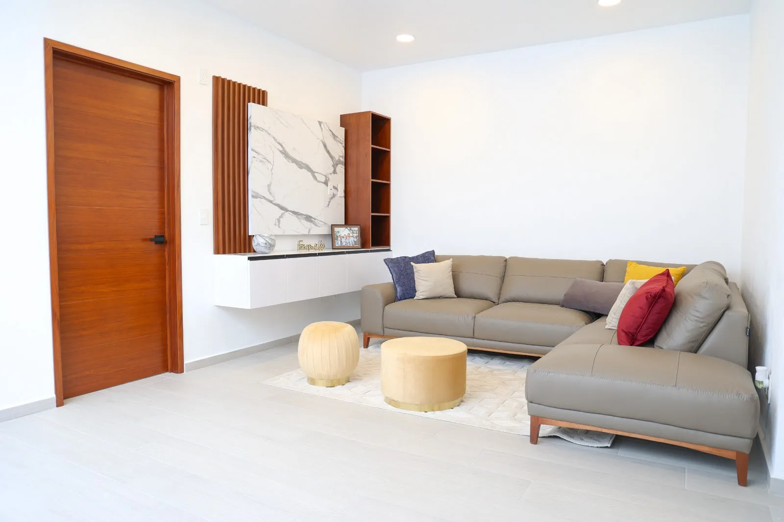 Family room con sala esquinera y muro de mármol
