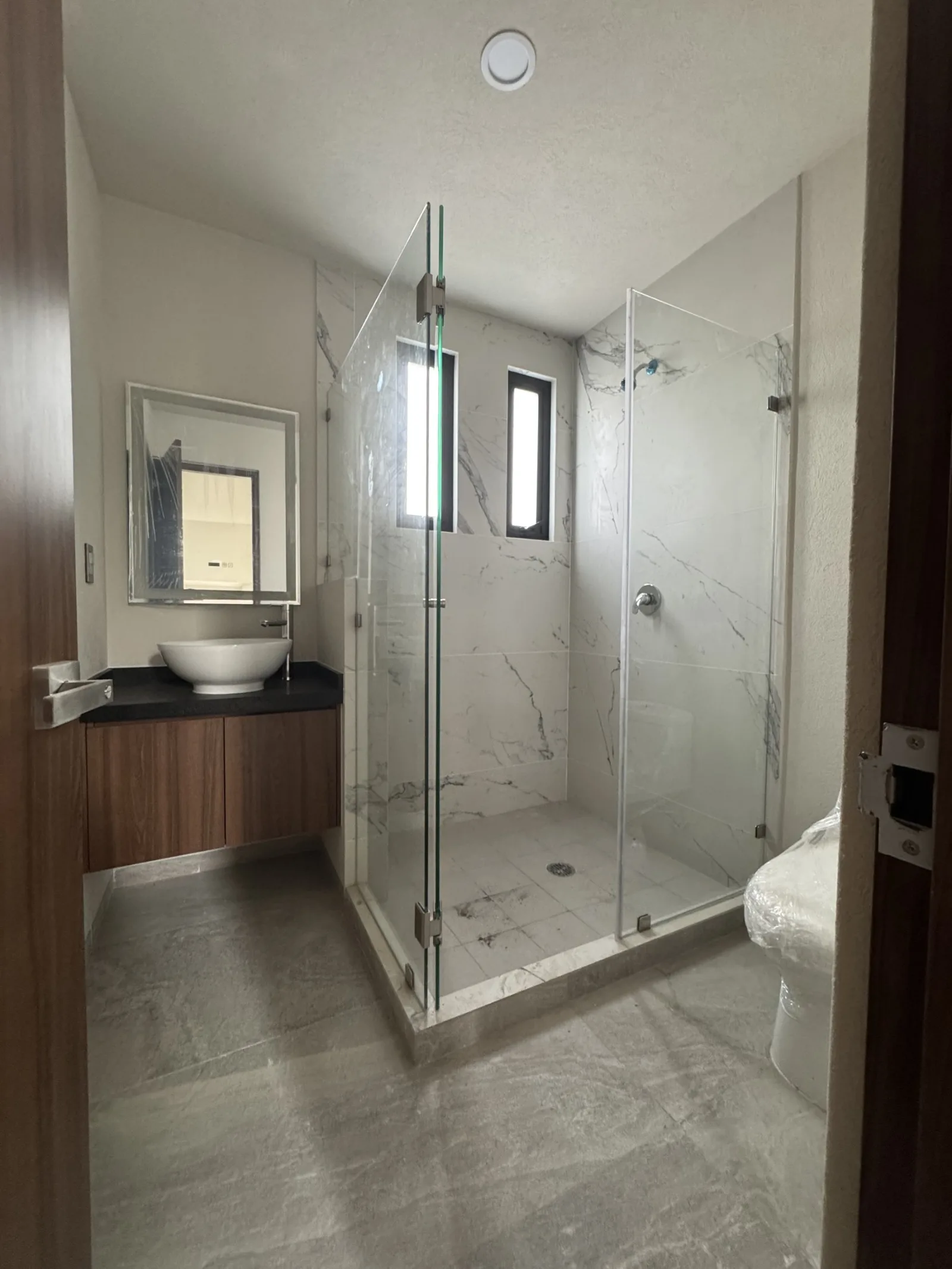 Baño con cancel de vidrio y lavabo sobre cubierta
