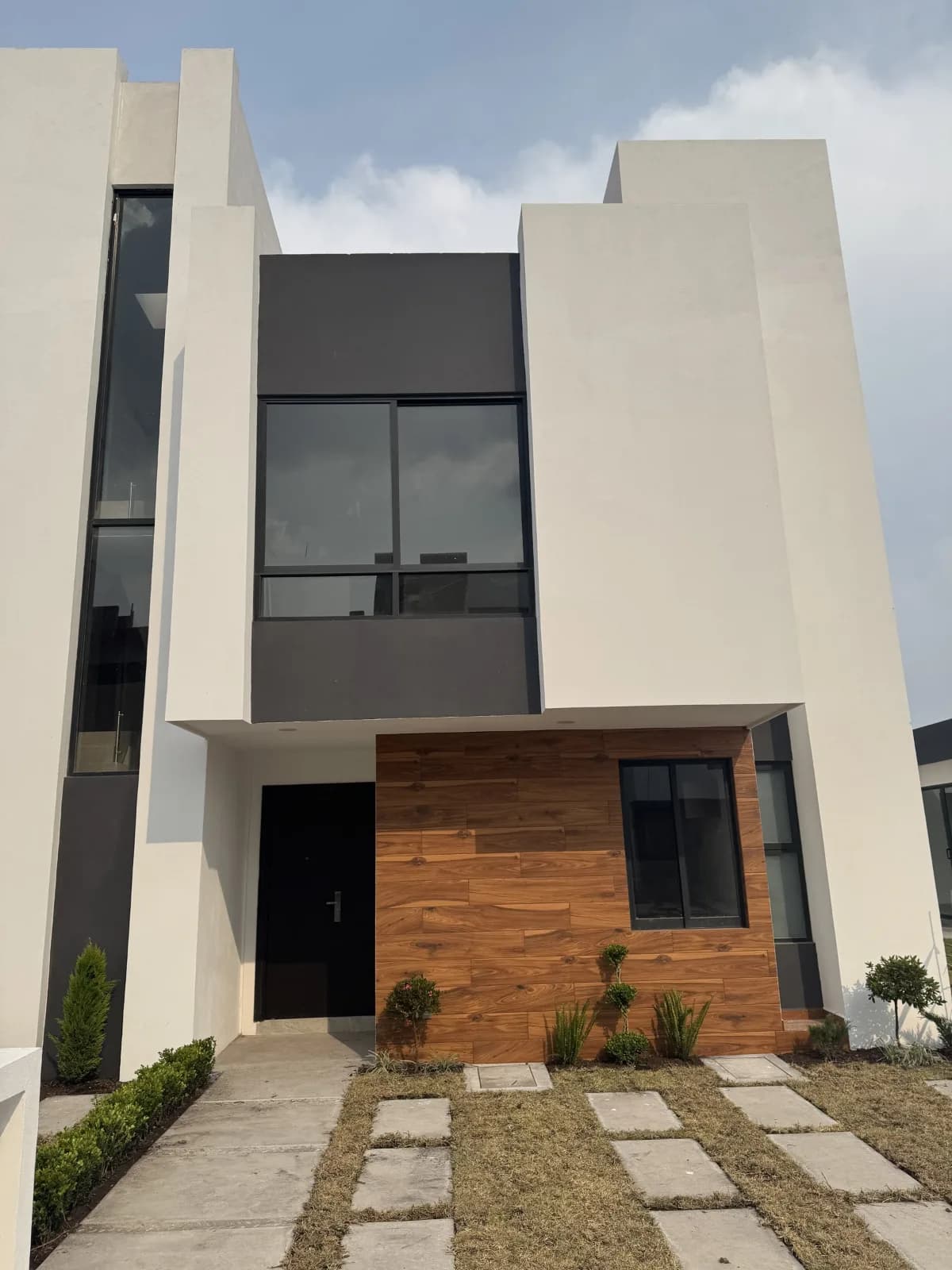 Fachada del modelo Mía en Esmeralda Residencial 14, casa de dos niveles con acabado de madera